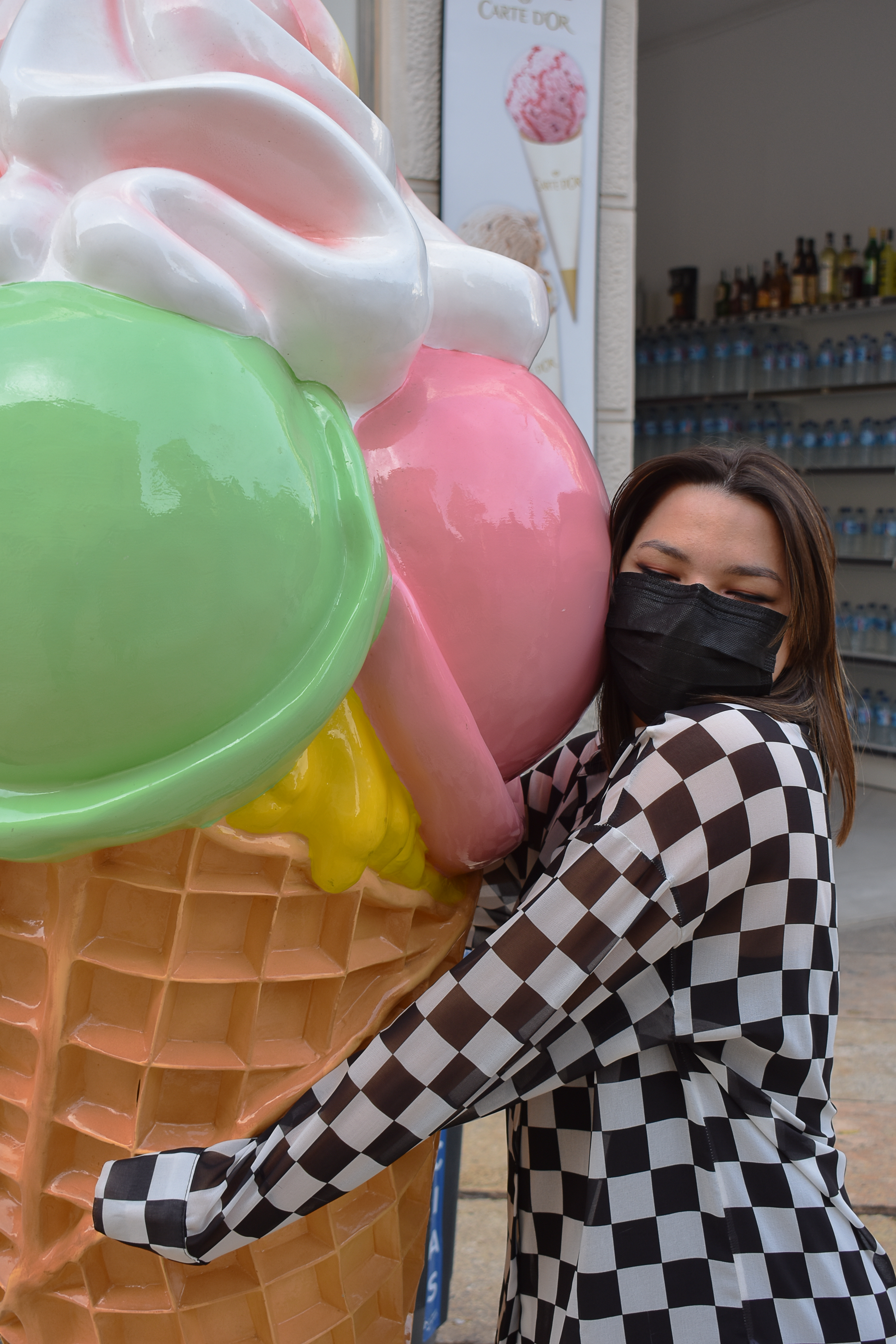 chica con mascarilla abrazando un helado